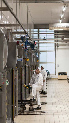 Operarios trabajando en la fábrica de Hero en España, alumbrada con iluminación mediante LED de bajo consumo de Philips