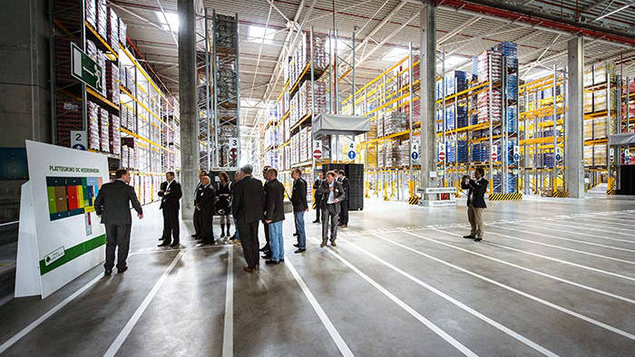 Gente asistiendo a una presentación en el almacén del Centro de distribución de Lidl iluminado por Philips Lighting