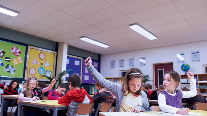 Niños atentos al profesor levantan la mano para responder a su pregunta - ambiente académico idóneo